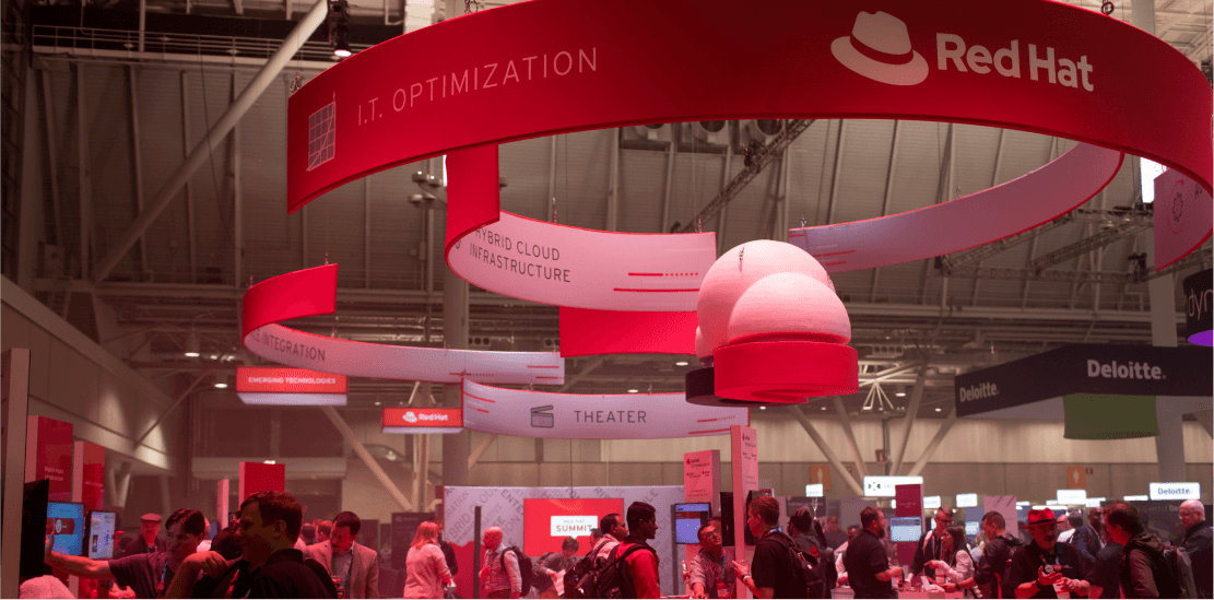 Booths at Red Hat Summit that feature the Red Hat logo.